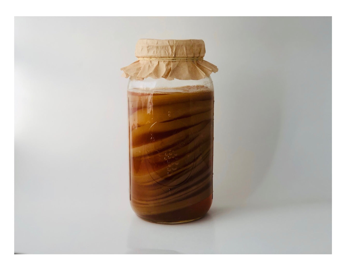 a jar filled with liquid sitting on top of a table. Brew Like a Pro : Kombucha SCOBY